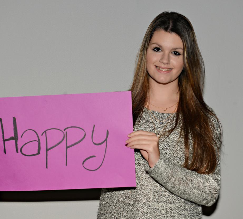 Girl holding sign saying "Happy"