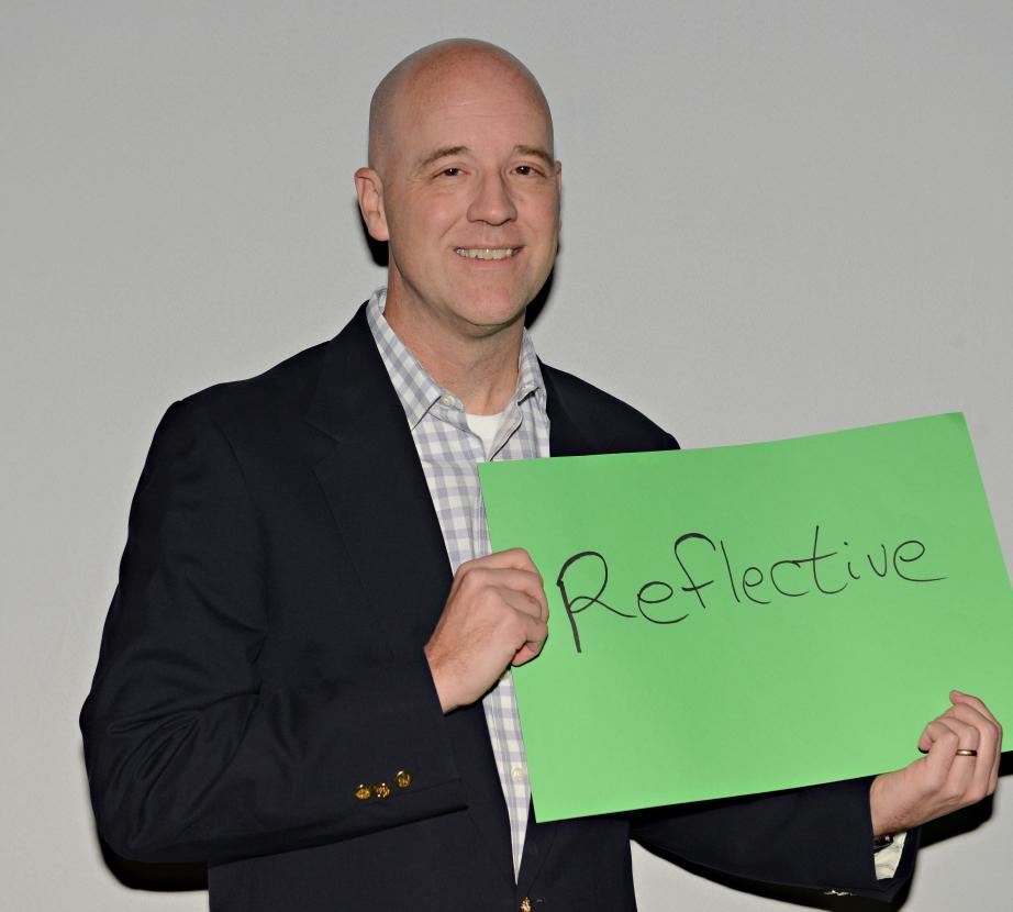 Man holding sign saying "Reflective"