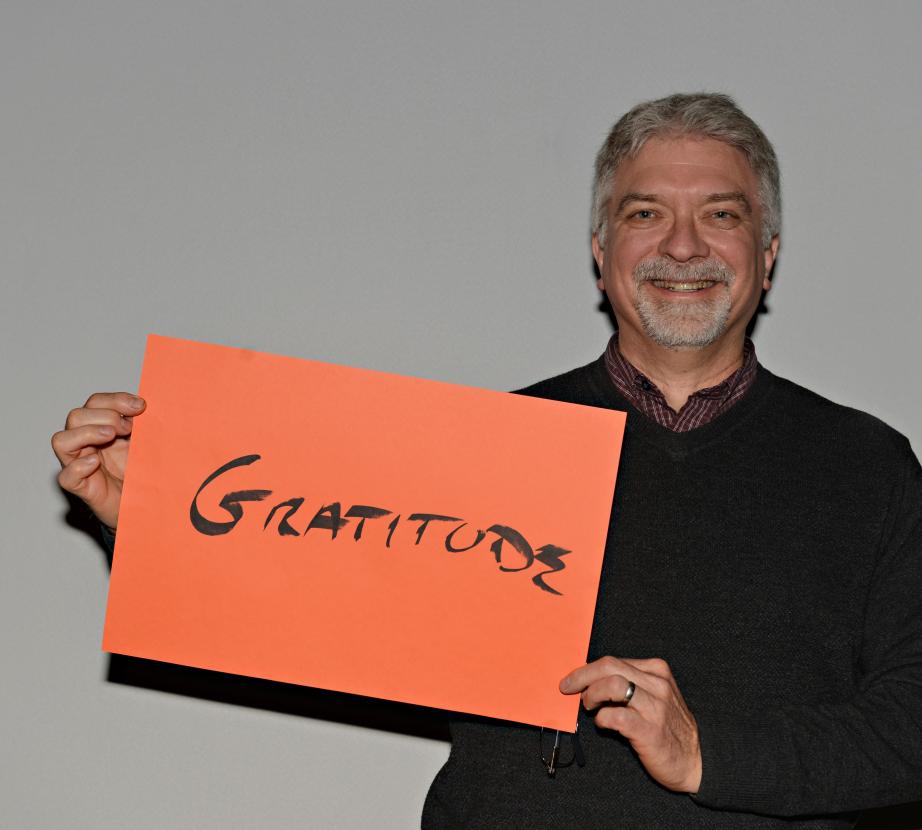 Man holding sign saying "Gratitude"