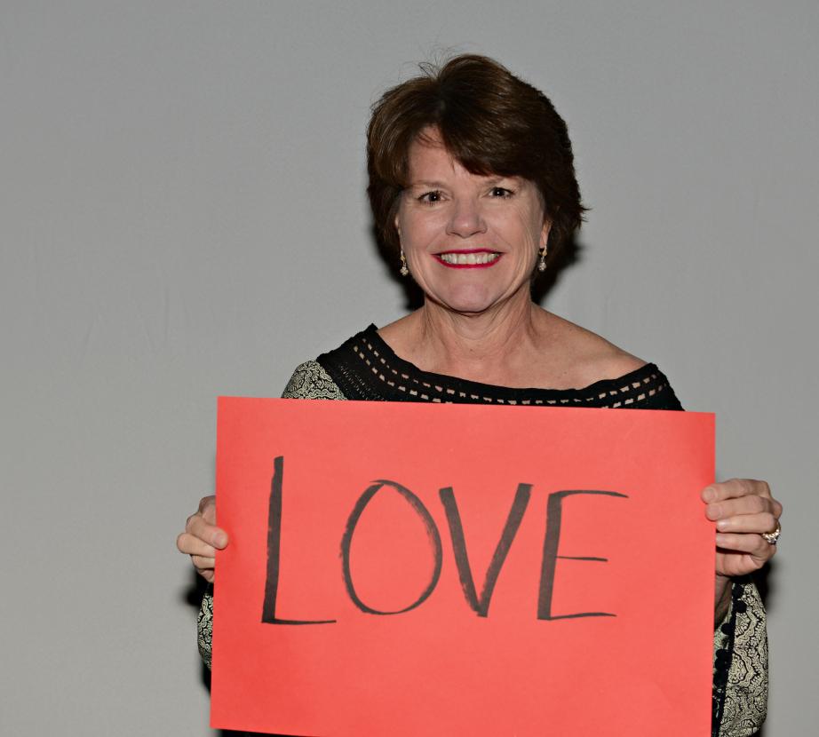 Woman holding sign saying "Love"