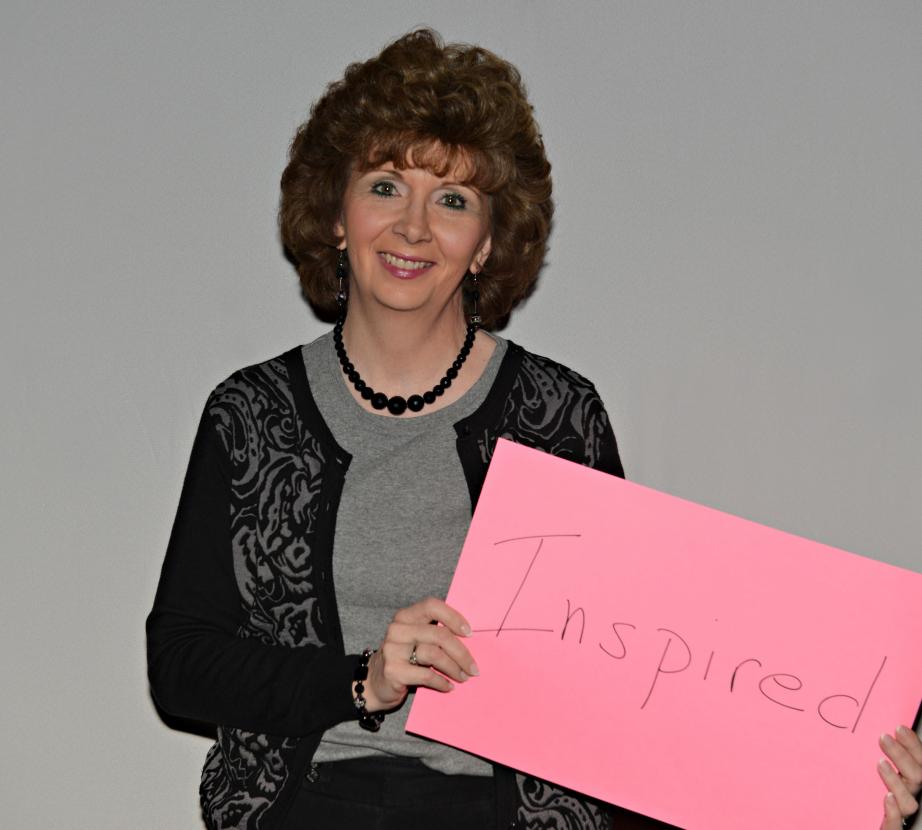 Woman holds sign saying "Inspired"