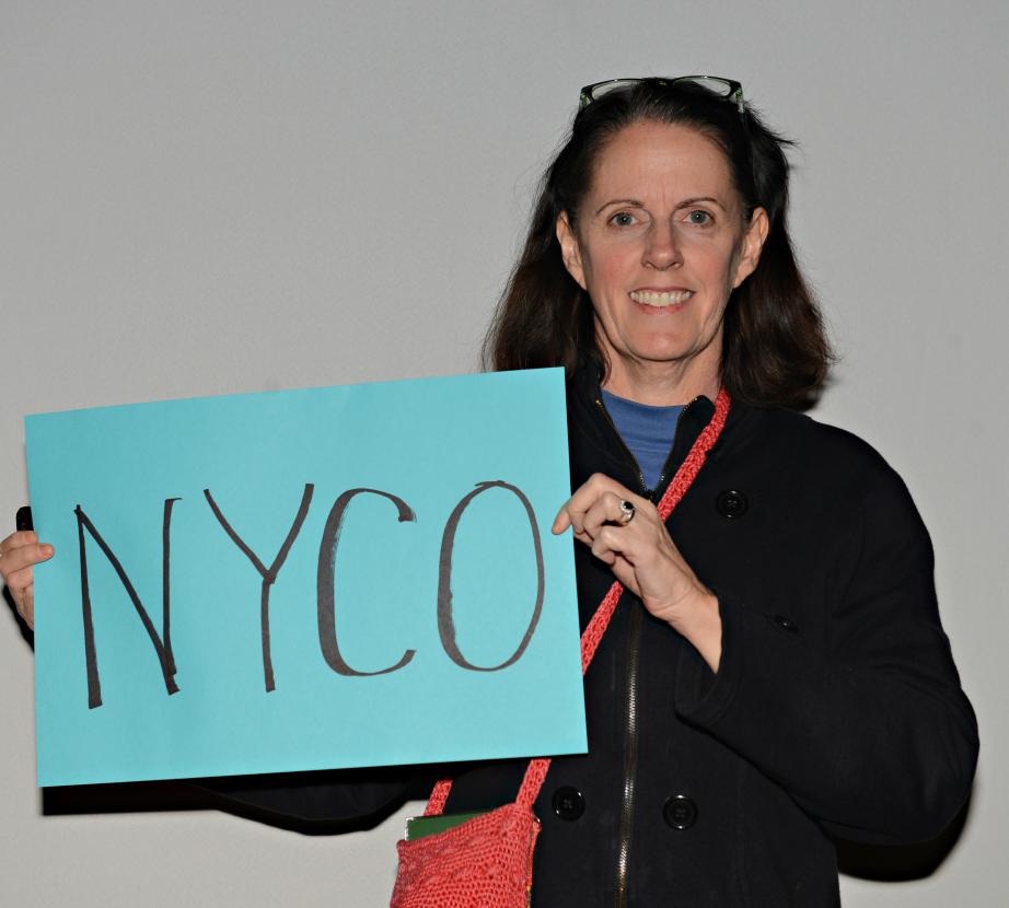 Woman holds sign saying "NYCO"