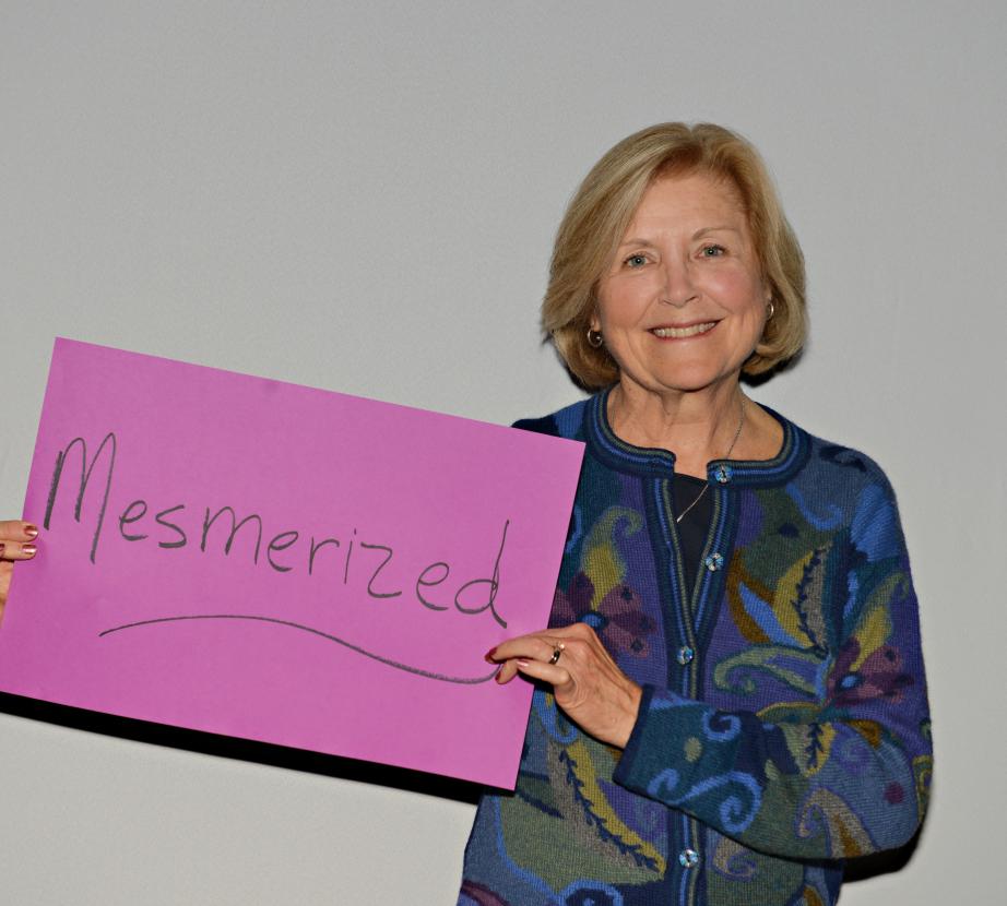 Woman holding sign saying "Mesmerized"