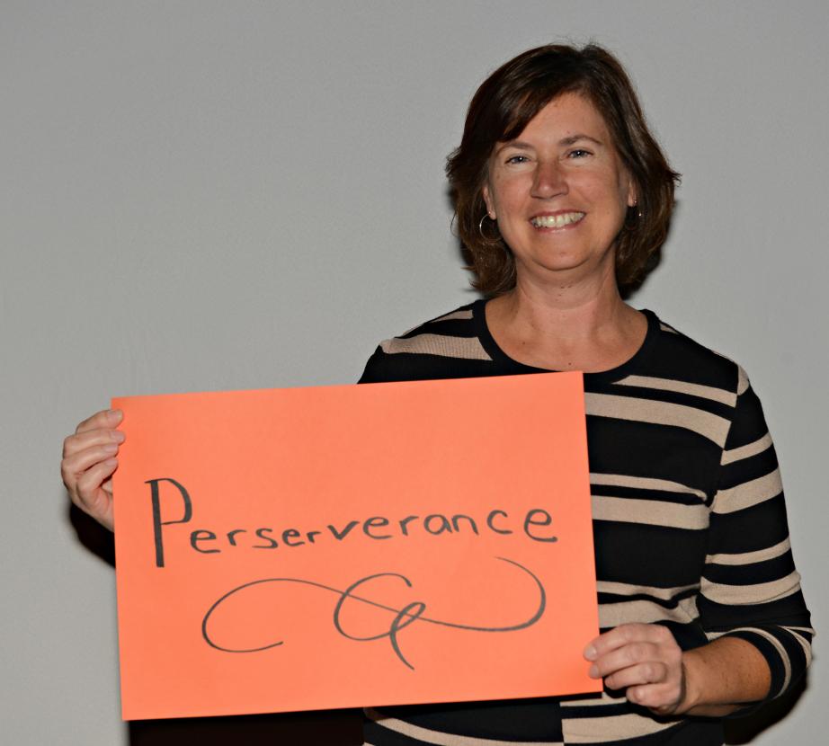 Woman holding sign saying "Perserverance"