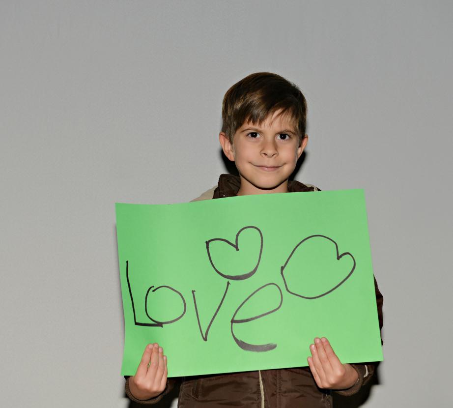Boy holding sign saying "Love"