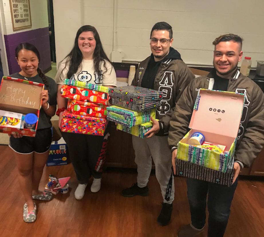 Students hold gift boxes.