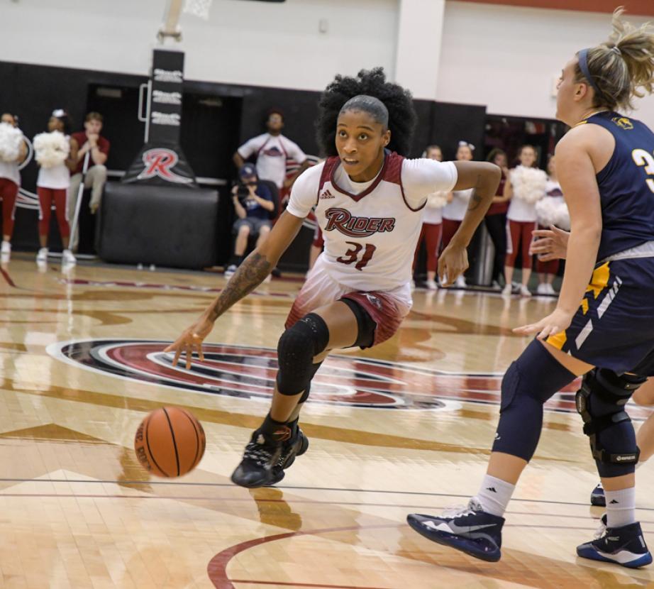 Basketball player dribbles down the court.