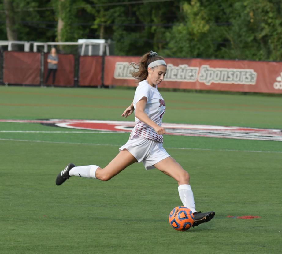 Soccer player kicks ball.