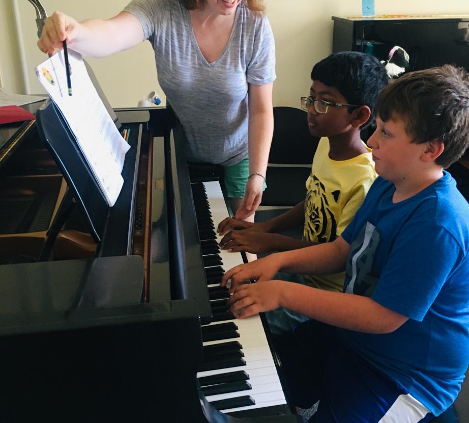 Teacher working with students at the piano