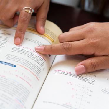 Students pointing in math textbook