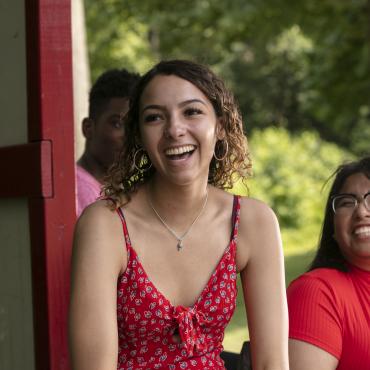 Students laugh while sitting outside