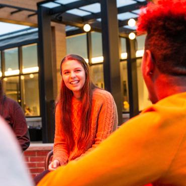 Students sit near campus fire pit