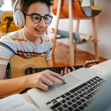 Student takes online guitar lesson