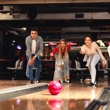 College students having fun while bowling.