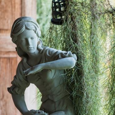 A sculpture of a woman in a garden.