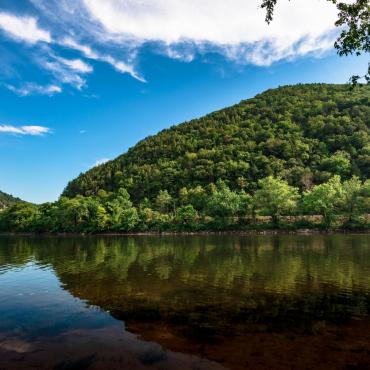 Mountain side by a body of water.