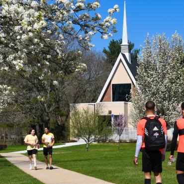 Students walk near Gill Memorial Chapel in spring