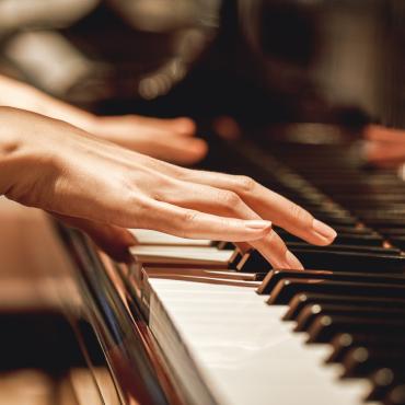 Closeup of woman playing piano.