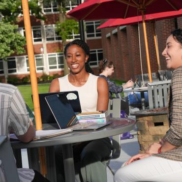 Graduate business students collaborate on a project using laptops
