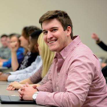 Male graduate student listening to faculty member