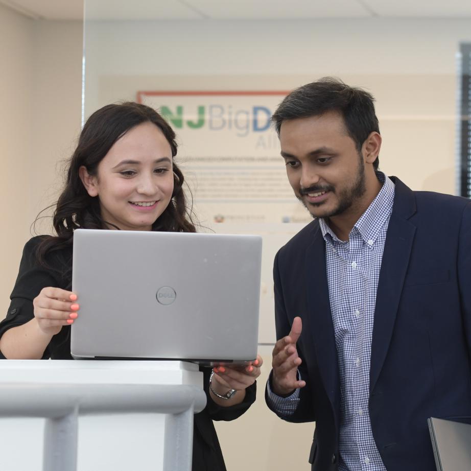 Two graduate business students working at a computer.