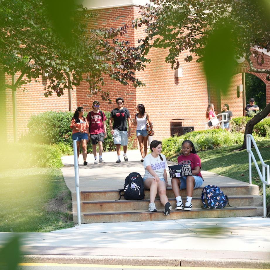 Groups of students walking and sitting outside on campus