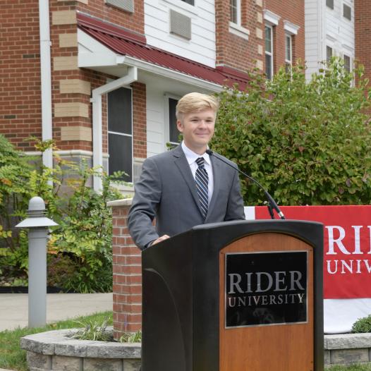 Student at a Rider podium giving a speech.