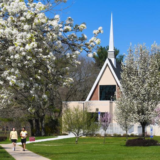 Students walk near Gill Memorial Chapel in spring