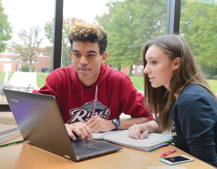 Two students use laptop